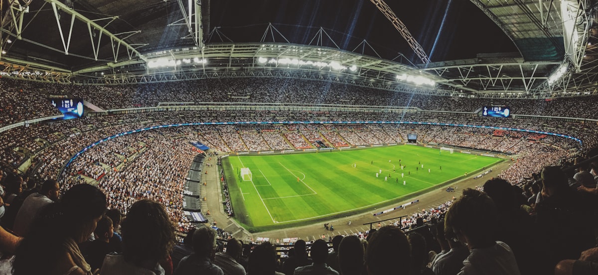 Fans watching a football game together inside a packed stadium